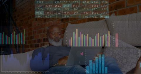 Analyzing Financial Charts on Laptop in Cozy Living Space