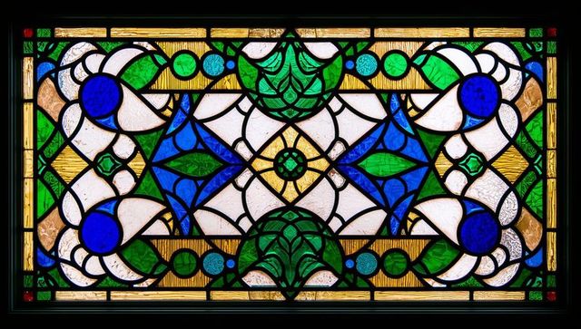 Art nouveau style stained glass with blue and green patterns