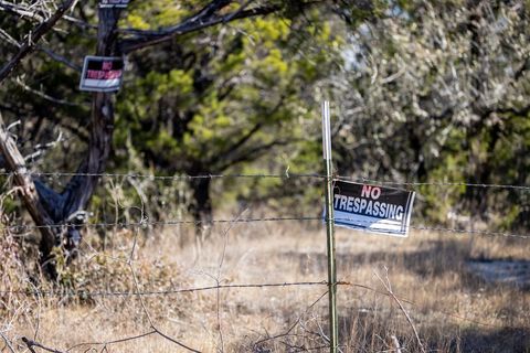 Rural no trespassing sign on barbed wire fence