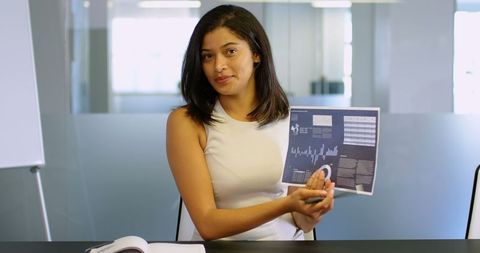 Confident Businesswoman Presenting Strategy Chart in Modern Office