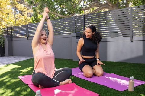 Diverse Female Friends Practicing Yoga in Sunlit Backyard