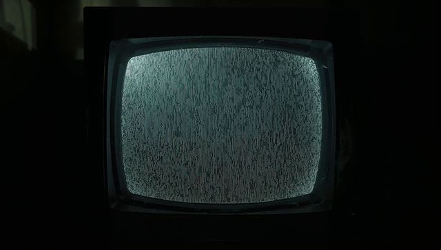 Glowing cyan static on curved vintage crt television in dim basement, eerie retro mood