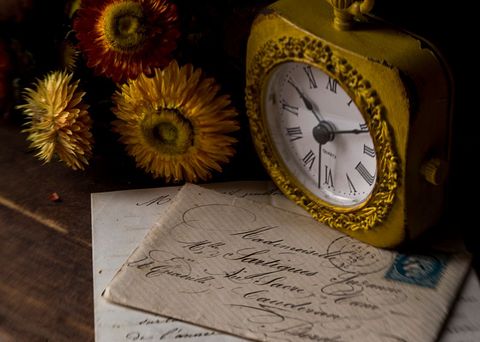 Vintage clock and old letters on wooden table