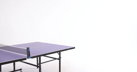 Folding purple table tennis table left side in white studio with net clamp and copy space