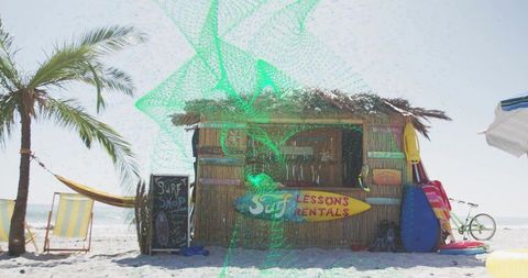 Bamboo tiki surf rental hut on sunny tropical beach offering surf lessons, board rentals, beach gear
