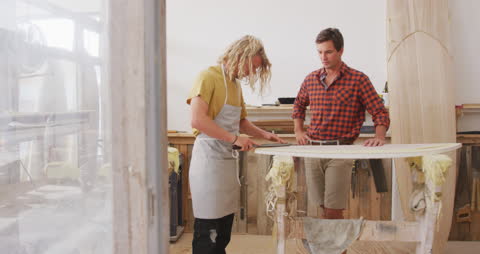 Artisans Shaping Wooden Surfboard in Studio