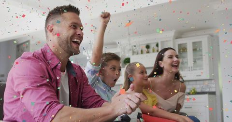 Excited Family Celebrating Watching Sports Game Together at Home