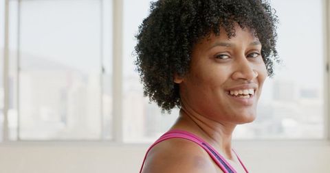 Focused Biracial Woman Practicing Yoga in Pink Top