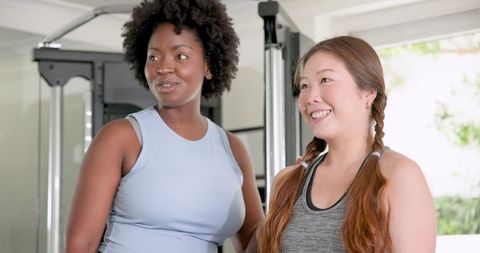 Fitness Trainer Instructing Woman on Exercise Routine in Gym