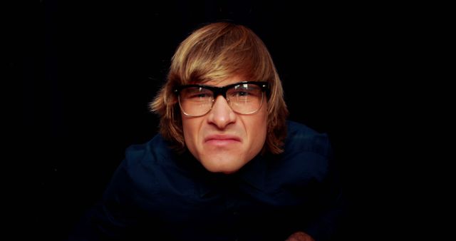 Young Man with Glasses Making a Funny Face in Dark Background - Download Free Stock Images Pikwizard.com