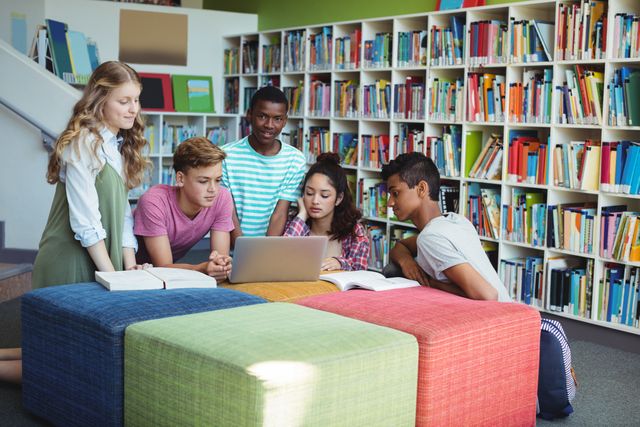 Group of diverse students collaborating on a project in a school library. Ideal for educational content, teamwork concepts, and promoting diversity in learning environments.