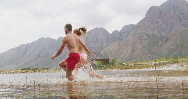 Couple enjoying mountain lake splash in summer - Download Free Stock Photos Pikwizard.com