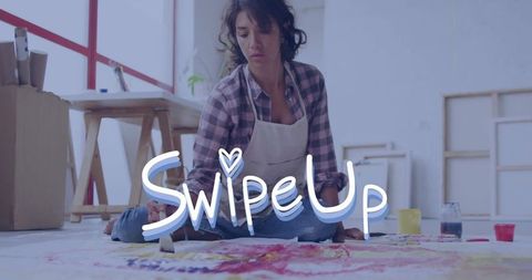 Female artist creating colorful floor canvas in studio workshop