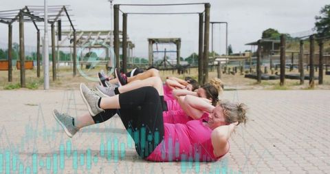 Outdoor group fitness training with six women in pink
