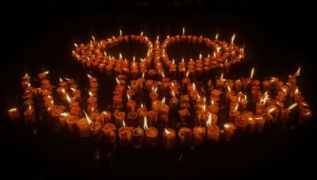Circle of Candle Flames Creating Warm Reflections in Shadowy Ambience