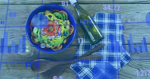 Rustic salad bowl on wooden table showing data overlays and blue analytics graphics