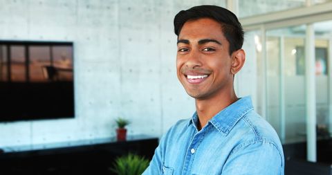 Confident young executive standing in modern office space