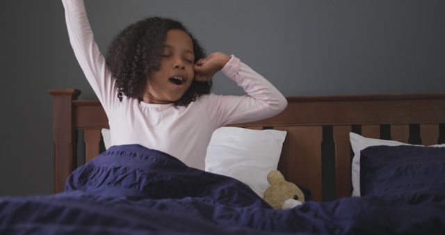 Happy african american girl waking up in the morning and stretching in bed at home - Download Free Stock Photos Pikwizard.com