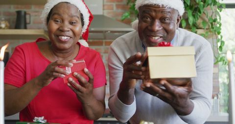 Joyful Elderly Couple Exchanging Holiday Gifts and Smiling