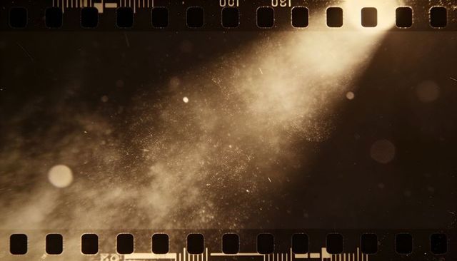 Golden diagonal light beam with dust motes and film sprockets, vintage cinematic grain