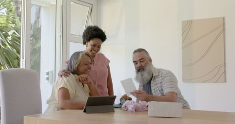 Happy intergenerational family using tablet in bright home