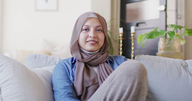 Smiling Woman in Hijab Sitting on Couch in Modern Cozy Living Room - Download Free Stock Images Pikwizard.com