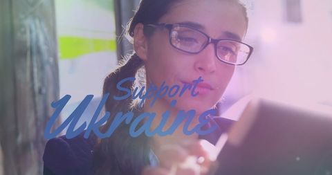 Supporting Ukraine Text Overlaid on Woman Using Tablet