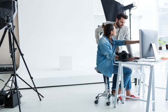 Photographers working together over computer in studio