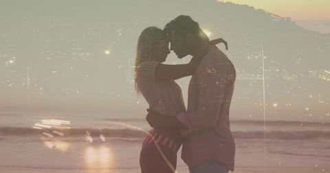 Romantic couple embracing at sunset on beach with city lights double exposure
