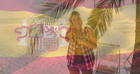 Young woman enjoying tropical beach vacation under palm fronds with spanish flag overlay