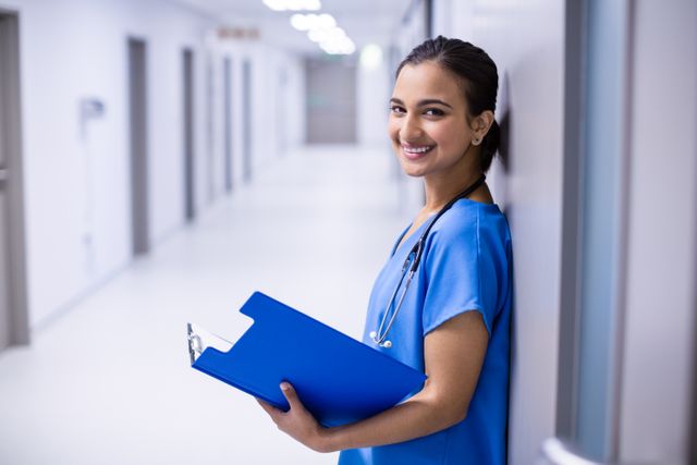 Portrait of female doctor holding file in corridor of hospital
