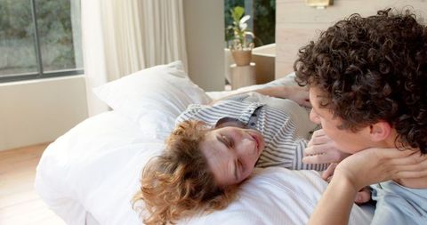 Joyful Gay Couple Relaxing on Bed at Home
