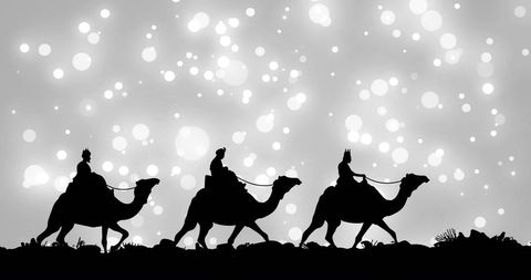 Silhouettes of wise men on camels under starry night sky