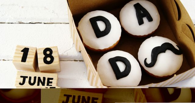 Cupcakes with letters spelling DAD and a mustache design celebrate Father's Day on June 18, with copy space. These treats add a sweet touch to the special occasion honoring fathers and father figures.