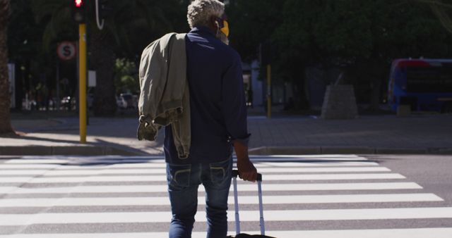 Man with Rolling Suitcase Crossing Street at Crosswalk - Download Free Stock Images Pikwizard.com