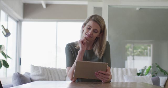 Thoughtful woman using tablet at home - Download Free Stock Images Pikwizard.com