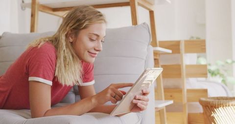 Young Woman Enjoying a Relaxed Weekend at Home Using Tablet