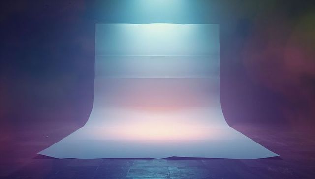 White paper backdrop under spotlight with ambient colors in studio