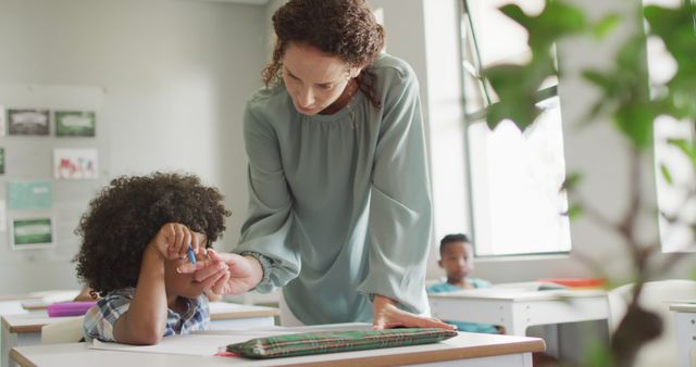 Teacher is assisting a young student in a modern classroom. Ideal for educational institutions, school promotions, and learning-related content, this image highlights the importance of teacher-student interaction and academic support.