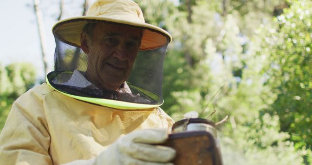 Elderly beekeeper in protective suit inspecting honeycomb in a lush outdoor environment. This can be used for articles or advertisements related to hobby farming, environmental conservation, sustainable agriculture, and the importance of bees in ecosystems.