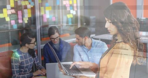 Woman Typing on Laptop in Collaborative Office Meeting