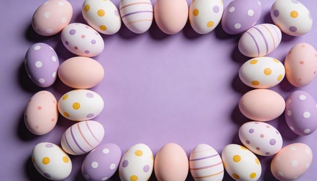 Pastel easter eggs forming oval frame on lavender surface for spring greeting and decor