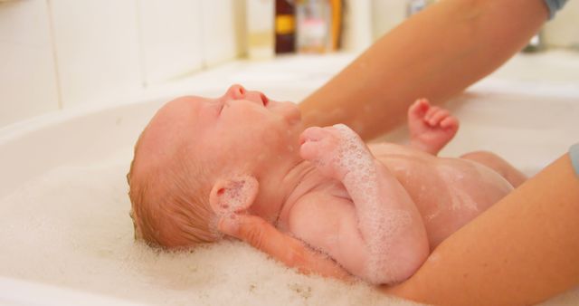 Parent Giving Newborn Baby A Bath In Bathtub With Soap Bubbles - Download Free Stock Images Pikwizard.com