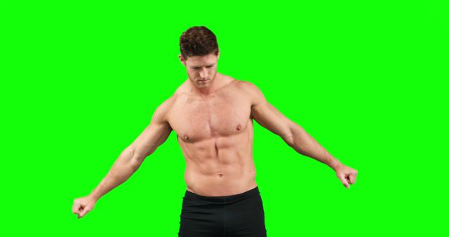 Muscular Man in Black Shorts Flexing Against Green Background - Download Free Stock Images Pikwizard.com