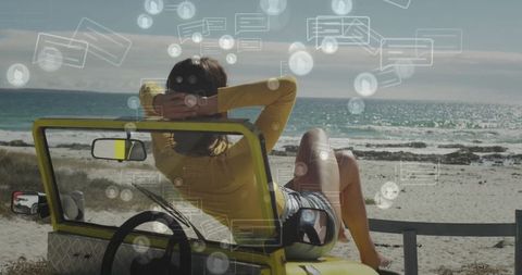Woman relaxing in dune buggy by the beach with digital overlay