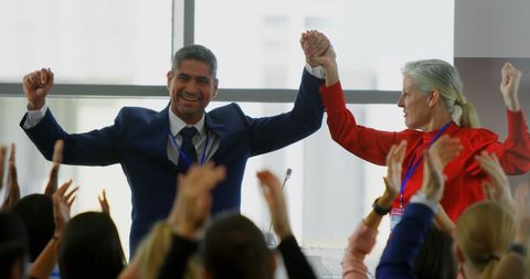 Business leaders celebrating success in conference amid enthusiastic applause