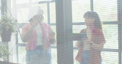 Two coworkers collaborating on project with tablet and smartphone in bright casual office