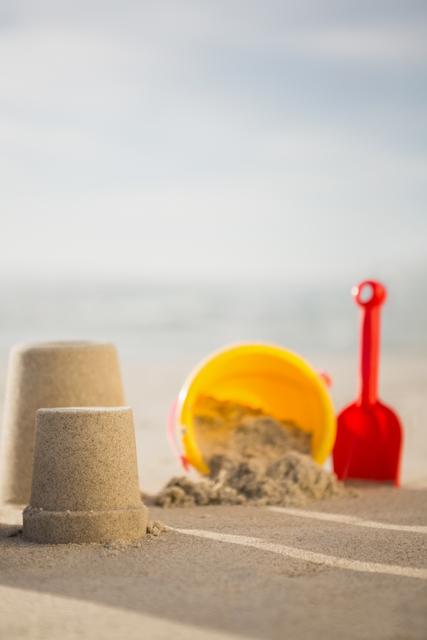 Bucket, spade and sand castles on tropical sand beach
