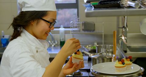 Young Chef Decorating Cupcakes with Precision in Professional Kitchen - Download Free Stock Images Pikwizard.com