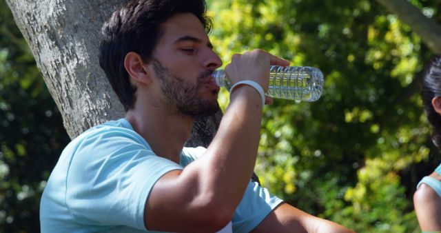 Man Drinking Water from Bottle in Park on Sunny Day - Download Free Stock Images Pikwizard.com